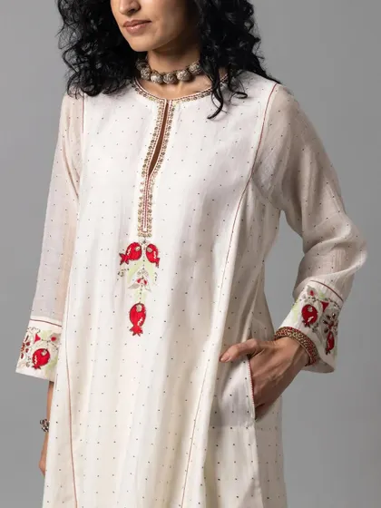An elegant off-white kurta with delicate pomegranate embroidery on the cuffs and placket. The subtle details and the comfortable silhouette make this a perfect piece for sophisticated daywear.