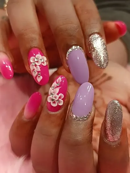 A playful and glamorous set combining multiple techniques. It features pink ombré, solid lavender, full silver glitter, and stunning 3D floral accents with rhinestone details.