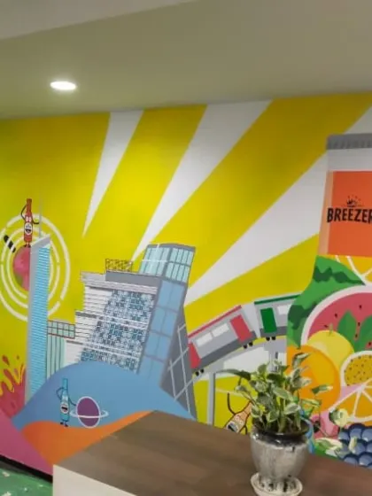 A closer look at the illustrative elements of the Breezer graffiti mural, including a cityscape and branded bottle. We seamlessly integrate brand elements into our custom art.