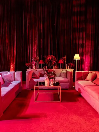 I created multiple lounge areas using contemporary velvet sofas in muted tones, allowing the intense red of the surrounding decor and lighting to remain the hero of the space.