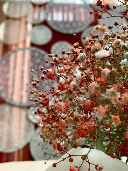 A macro shot of delicate, spray-painted baby's breath against a textured backdrop. This artistic detail adds a unique touch to our floral arrangements.