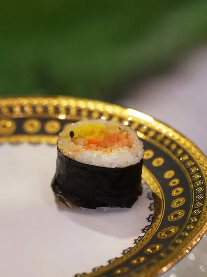 A close-up of a single piece of our Veggie Kimchi Kimbap. This Korean-style roll is packed with seasoned rice, crunchy vegetables, and tangy kimchi for a burst of flavour.