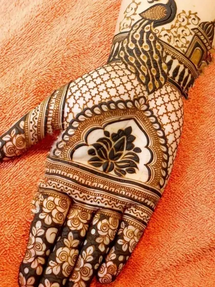 A classic design featuring a lotus in the center of the palm, with a peacock motif on the wrist. The fingers are decorated with delicate floral patterns.