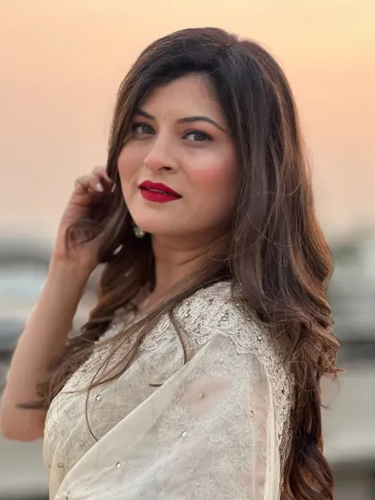 A close-up of Savaniee's glamorous look. The bold red lip is the statement piece, paired with soft, shimmering eye makeup.