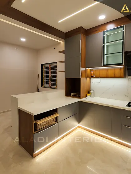 Another view of the kitchen with grey cabinets and a white countertop breakfast bar. This angle shows the pull-out wicker basket storage, a practical and stylish solution.