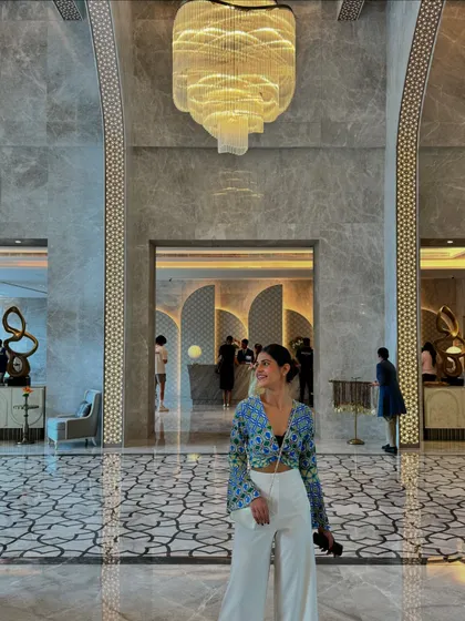 An outfit for exploring a luxury hotel in Jaipur. I paired a vibrant floral print top with wide-leg white trousers for a chic and comfortable look that feels both modern and resort-ready.