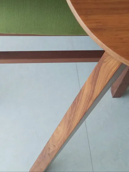 A detail shot of a custom dining chair, focusing on the joinery and material grain of the teak wood. This image highlights the craftsmanship and attention to detail that goes into our bespoke residential furniture.