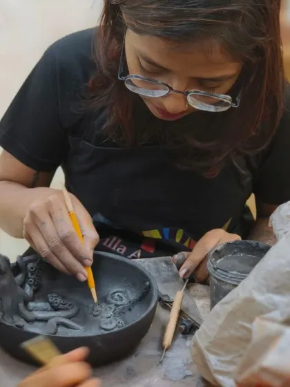 A student adds intricate details to an ocean-themed bowl, sculpting a tiny octopus and swirling tentacles. Our sculpting courses allow you to create detailed narrative scenes in clay.