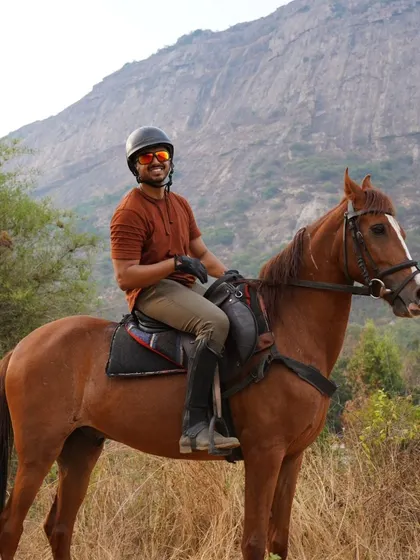 A smiling rider on his brown horse, taking a break during the safari. The joy of the ride is evident.