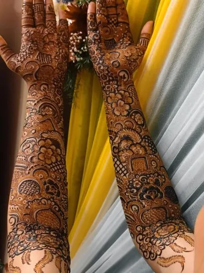 A full bridal henna design with a mix of floral and geometric patterns. The design is dense and detailed, creating a stunning look for the bride.