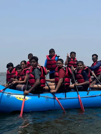 A happy group of summer campers poses for a photo in a raft on the clear waters of Vani Vilas Sagar.