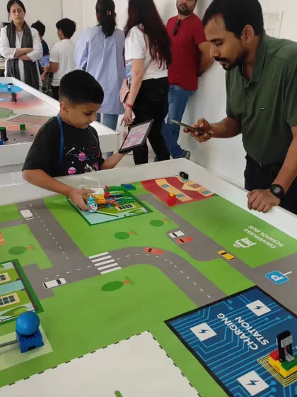 A parent helps his child test their robot during our internal competition. We encourage family participation to make the learning experience even more rewarding.