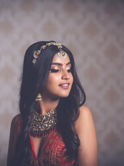 A soft and dreamy portrait. The bride's gentle expression is complemented by the soft-focus background and the warm tones of her makeup.