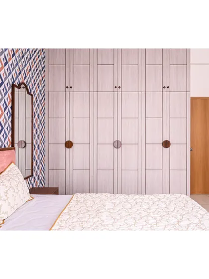 A view of the custom floor-to-ceiling wardrobe with its unique circular wooden handles, designed for the "Anchorage 162" project.