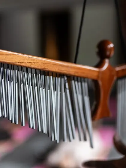 A practitioner holds a set of bar chimes, another key instrument in my sound healing sessions. Their cascading, ethereal notes create a magical atmosphere that helps release stress and elevate the spirit.