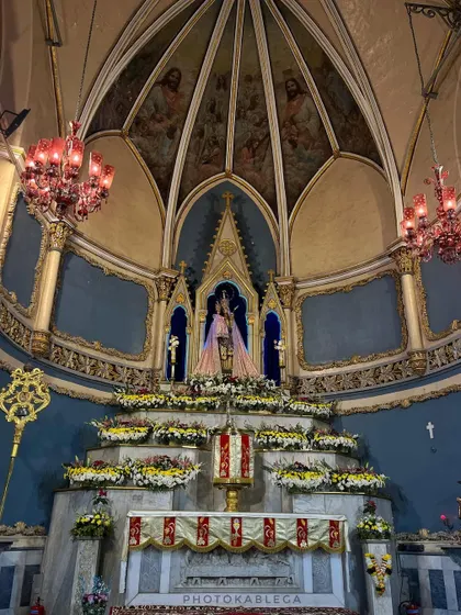 The ornate altar of Mount Mary Church, richly decorated with flowers and candles for the Christmas celebration.