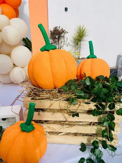 More details from the pumpkin party, with decorative pumpkins placed on hay and wooden crates.