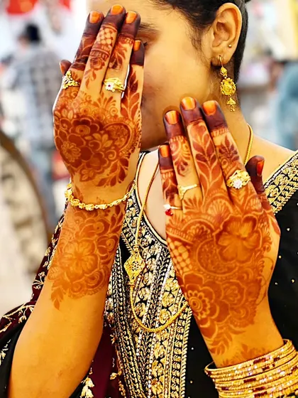 A candid shot of a guest at a wedding, her hands adorned with my henna, which has developed into a beautiful dark stain.