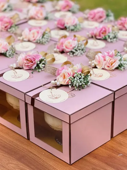 Your perfect little thank you, wisqed to perfection. These pink dessert boxes are decorated with intricate floral arrangements and custom branded tags, making them an elegant party favour.