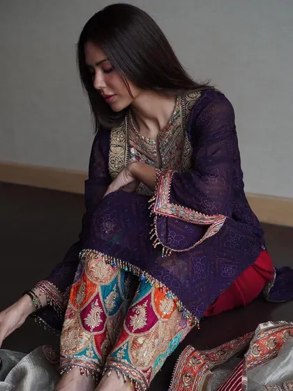 A seated portrait that offers a different perspective on the outfit. The focus here is on the beautiful embroidery of the kurta and the intricate patterns on the salwar.