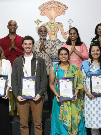A group of students celebrating their 300 and 500-hour TTC certifications, a significant achievement in their yoga journey.
