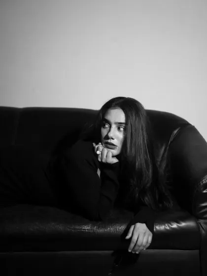 A studio session with a model in a black dress, showcasing a range of poses from pensive to powerful. The lighting is controlled to sculpt the subject and create a sophisticated mood.