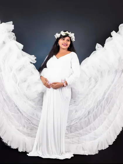 The detachable ruffle sleeves on this white gown create a stunning angel-wing effect, adding a touch of drama to your maternity photos.