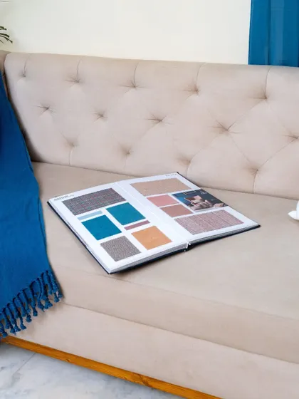 Another view of the sofa with the fabric swatch book, emphasizing our collaborative design process where clients are involved in every choice.