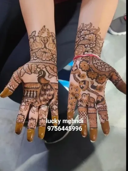 A pair of hands with different but complementary designs. One features a large peacock, while the other has an elephant, showcasing traditional animal motifs in guest mehndi.