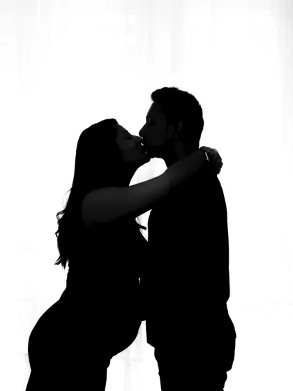 A classic silhouette of a couple's kiss, beautifully framed against a white background for a timeless and romantic image.