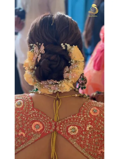 A close-up showing the delicate details of the butterfly accessories nestled among the flowers in this beautiful bridal updo.