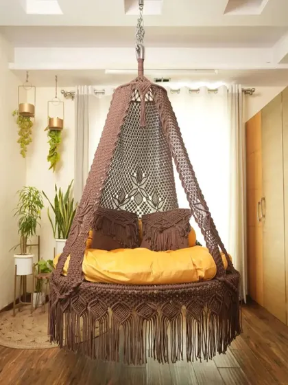 This dual seater swing in a light brown color offers a neutral, earthy tone that complements many decor styles. The macrame-detailed pillows are included.