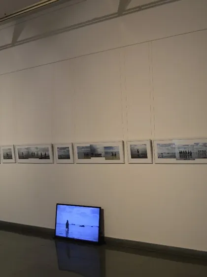 The full installation of Surekha's 'Sea Watchers', a series of panoramic photographs accompanied by a video screen on the floor.
