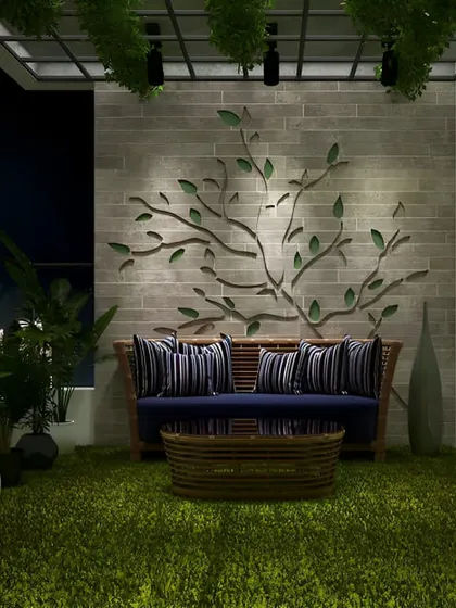 This night-time view shows how lighting can create drama and art. Spotlights highlight a beautiful tree branch wall sculpture, while the surrounding plants are softly illuminated, turning the balcony into a private, moody retreat.
