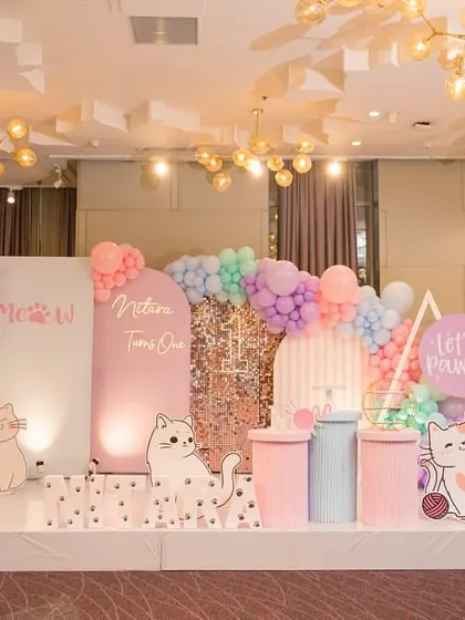 A wide view of the cat-themed party stage, showing the full setup with balloon garlands and personalized "Meow" signage.