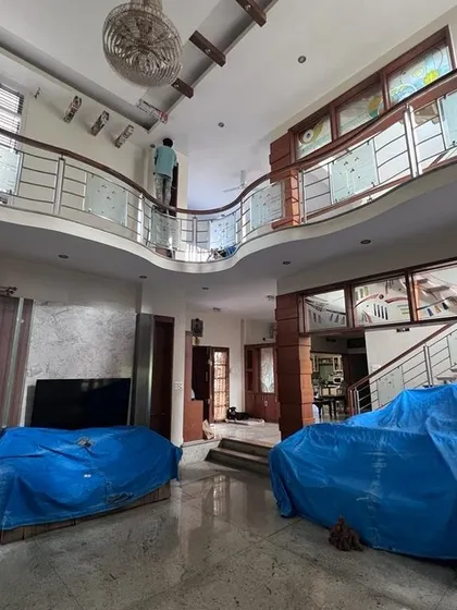 I handle projects of all sizes, including large duplex homes with high ceilings and complex layouts. This photo shows my team carefully prepping a spacious living area, ensuring all furniture is securely covered before we begin the interior painting process.