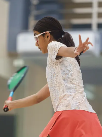 Samairah Bhandare captured mid-swing. The motion blur of the racket contrasts with her sharp focus, conveying the speed and power of her game.
