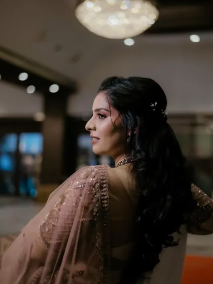 A side profile showcasing the soft, wavy hairstyle created for this reception look. The hair is styled to complement the makeup and the overall romantic theme.