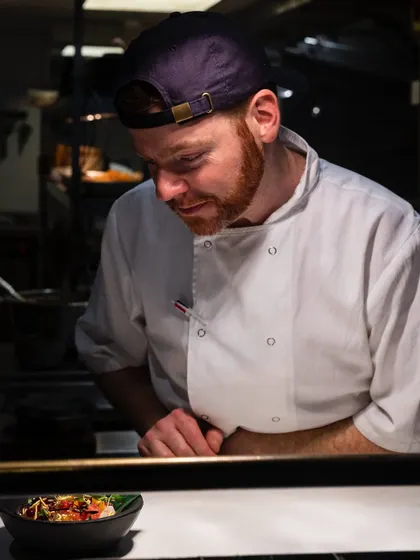 Capturing a chef in their element. This candid action shot from a London restaurant kitchen tells a story of focus, craftsmanship, and dedication to the final dish.