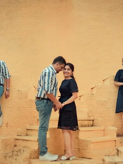 A creative family pre-wedding shoot at a yellow stepwell, capturing the couple's love story with their family present.
