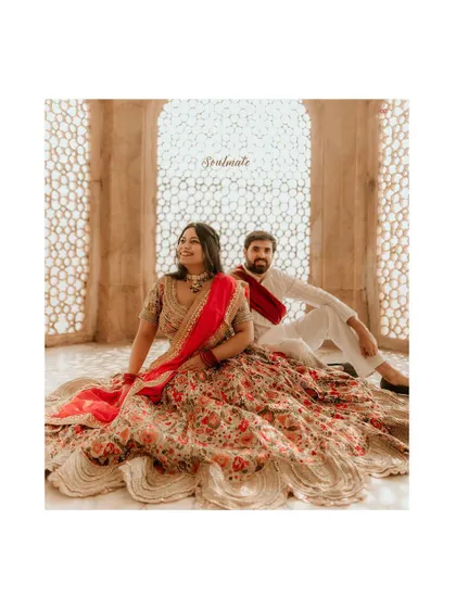 A stunning portrait inside Amer Fort, using the intricate 'jaali' latticework to create a backdrop of light and shadow for this regal couple.