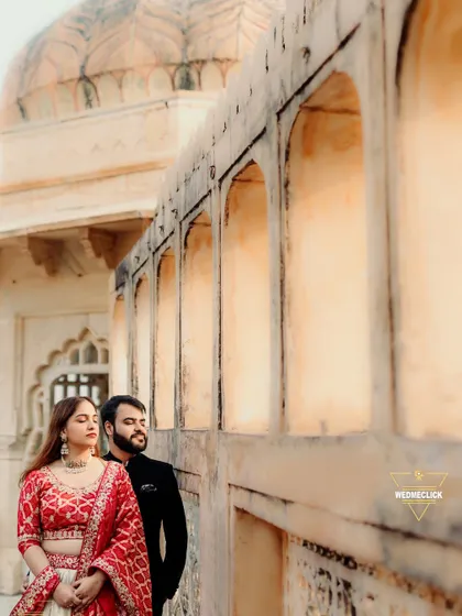 A quiet moment against the warm, textured walls of a Rajasthani fort. The contrast between his dark suit and her vibrant lehenga stands out beautifully. This is a great example of a serene, editorial-style portrait from a destination couple shoot.