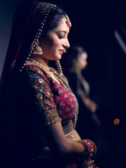 A profile shot of a bride, with her reflection visible, creating an artistic and introspective portrait.