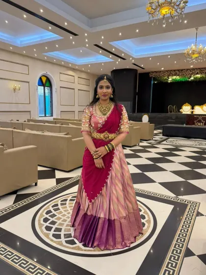 A client looking regal in a multi-toned pink and purple half saree for her engagement.