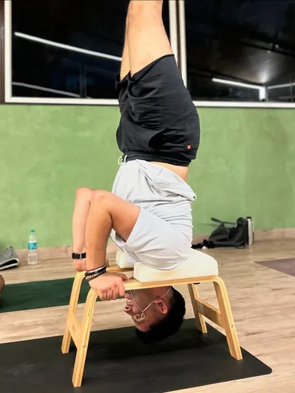 A member uses a headstand bench to safely practice inversions, building confidence and strength without pressure on the neck.