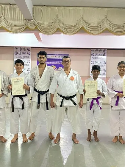 The gang from our Silicon City dojo poses with their new certificates after a successful belt exam, standing alongside their proud senseis.