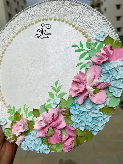 A closer look at the floral arrangement on the wedding ring platter, showing the delicate pink roses and blue hydrangeas.