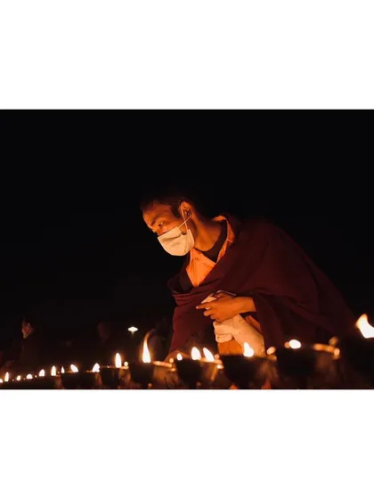A monk carefully lights a row of butter lamps at the Mahabodhi Temple. This image highlights my focus on the small, intimate details and quiet acts of devotion that are often the most powerful parts of a spiritual ceremony.