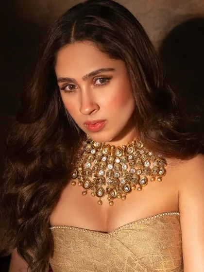 A stunning close-up of Pashmina Roshan, her face framed by the glow of the elaborate gold choker.