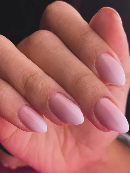 A perfect example of a soft and subtle ombré. These almond-shaped nails feature a beautiful, milky blend from a sheer pink base to a soft white tip, creating a clean, elegant, and natural-looking enhancement.
